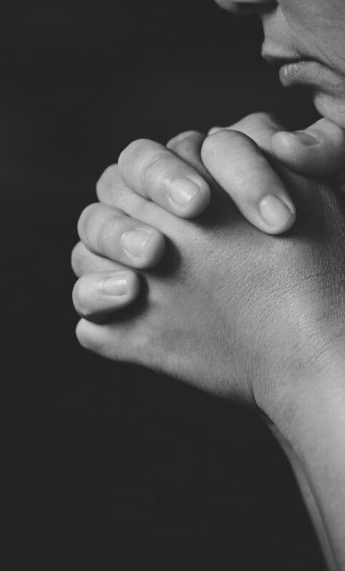 Hombre preocupado con las manos entrelazadas apoyado en la barbilla, representando la búsqueda y localización de personas por detectives privados en Málaga